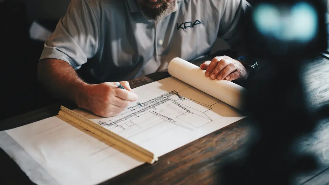 Profissional de reformas desenha numa planta de obra
